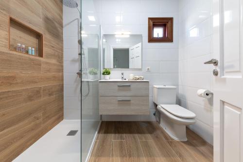 uma casa de banho com um WC e uma cabina de duche em vidro. em Sea Palms Lanzarote em Playa Blanca