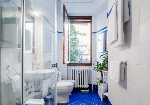 a bathroom with a toilet and a sink and a window at Appartamento Blu a Milano zona Ripamonti vicino allo IEO in Milan