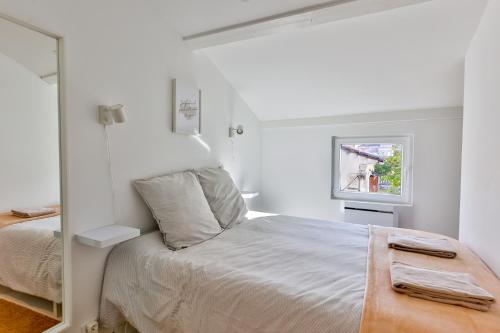a white bedroom with a bed and a mirror at Le Mimosa #Netflix #Centre-ville in Cognac