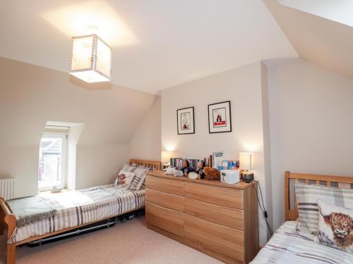 a bedroom with two twin beds and a dresser at Learig in Buckie