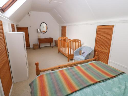 a bedroom with a bed and a crib at Banc Y Capel in Newport