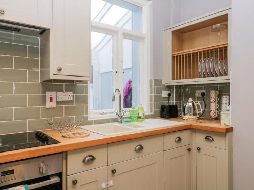 eine Küche mit einem Waschbecken und einem Fenster in der Unterkunft 7 Railway Cottages in Ulverston