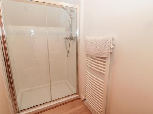 a shower with a glass door in a bathroom at Carriage House in Coldstream
