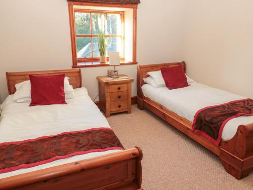 a bedroom with two beds and a window at Carriage House in Coldstream