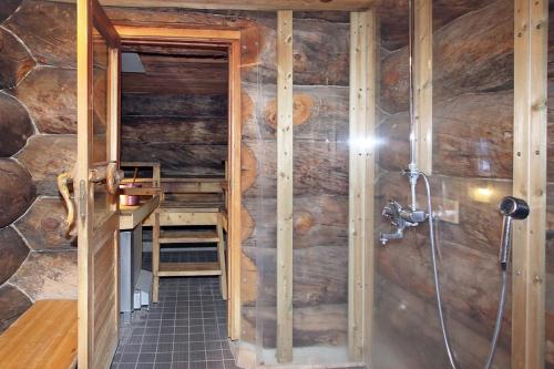 a bathroom with a shower in a log cabin at Kuukkeli Apartments Pikku-Hirvas ja Porotokka in Saariselka