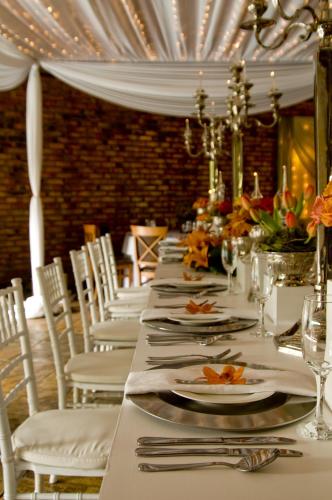 a long table with white plates and silverware at North Haven Country Estate in Honeydew
