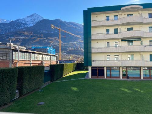 a building with a green lawn in front of it at Apartamento da Jenny in Aosta