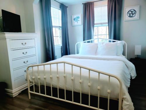 a bedroom with a white bed and a dresser at Private Duplex Near BWI/Easy Access to I95 in Linthicum Heights