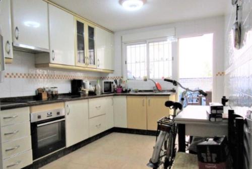 una cocina con armarios blancos y una bicicleta estacionada en ella en Victoria Hospedaje, en Alicante