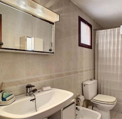 y baño con lavabo, aseo y espejo. en Victoria Hospedaje, en Alicante