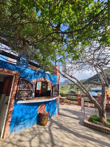 a blue building with a tree in front of it at Complexe rueda in Ouslaf