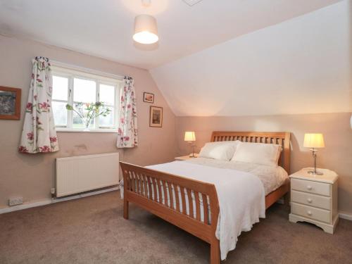 ein Schlafzimmer mit großem Bett und Fenster in der Unterkunft Palmers Green Cottage in Taunton