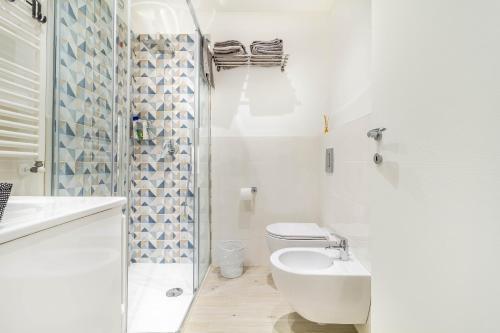 La salle de bains blanche est pourvue de toilettes et d'un lavabo. dans l'établissement Casaballi Milano MM3 Trilocale, à Milan