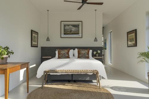 a bedroom with a white bed and a table at Magnifik Montagu in Montagu