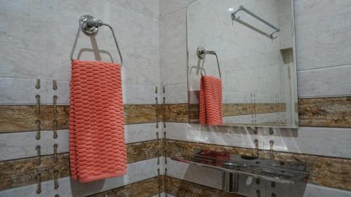 a bathroom with two red towels hanging from a mirror at Angela's Boutique Homes Dharamkot in Dharamshala