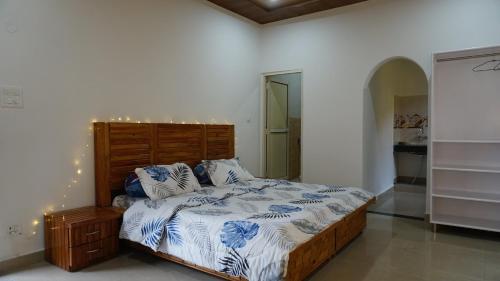 um quarto com uma cama com lençóis azuis e brancos em Angela's Boutique Homes Dharamkot em Dharamshala