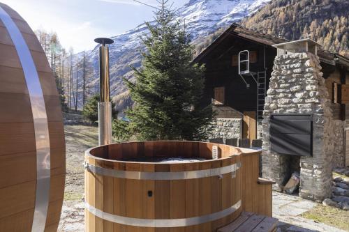 a wooden hot tub in front of a house at Polaris 1 006 - LUXE & SKI LIFT apartment 6 pers in Zinal