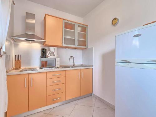 a kitchen with wooden cabinets and a white refrigerator at Villa Alpa in Umag