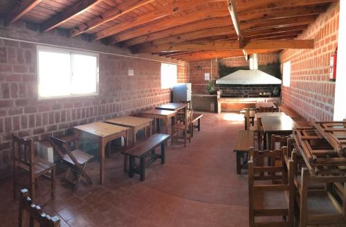 un restaurante con mesas de madera y sillas en una habitación en Alquileres Bosero en Las Toninas