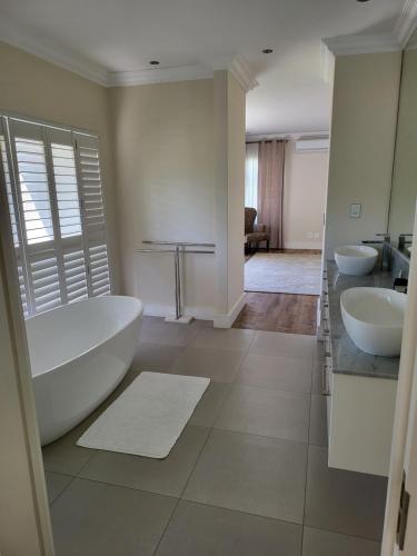 a bathroom with two sinks and a large tub and a tub at The Grandstancia in Cape Town