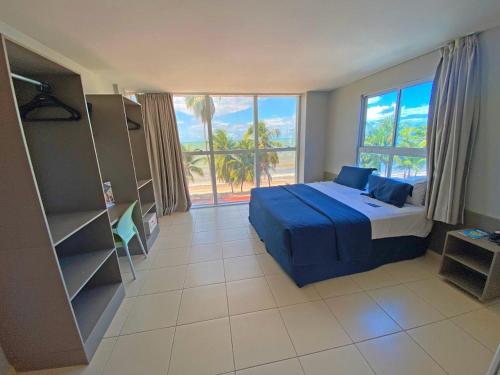 1 dormitorio con cama y ventana grande en Flat Beira Mar do Cabo Branco Quarto com linda vista para o mar, en João Pessoa