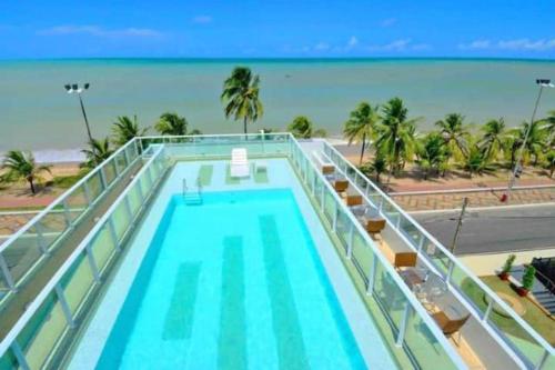 una piscina con vistas a la playa en Flat Beira Mar do Cabo Branco Quarto com linda vista para o mar, en João Pessoa