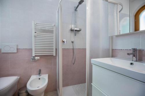 uma casa de banho com um chuveiro, um WC e um lavatório. em Il Bianconiglio em Peschiera del Garda
