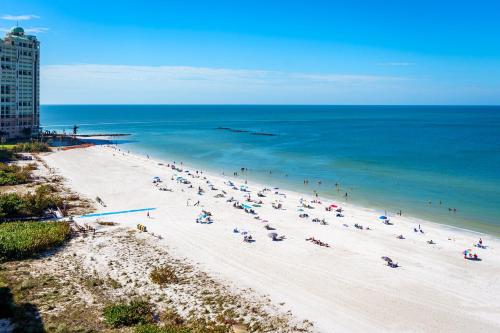 eine Gruppe von Menschen an einem Strand mit Blick auf das Meer in der Unterkunft Charming 2 Bed South End Beachfront Condo at Popular Seawinds in Henry Key