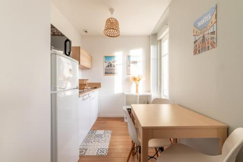 une petite cuisine avec une table et un réfrigérateur dans l'établissement Cocoon Malouin - à proximité de la plage, à Saint-Malo