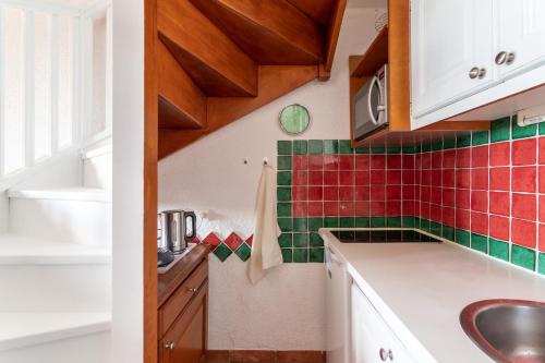 - une cuisine avec du carrelage rouge et vert sur le mur dans l'établissement La Lavandière, à Bormes-les-Mimosas