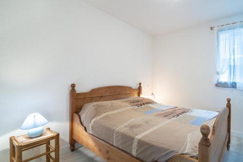 1 dormitorio con cama de madera y lámpara en una mesa en L'Isard, en Barèges