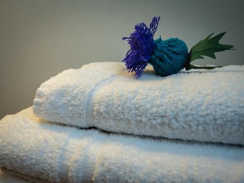 a stack of towels with a blue yarn on top at Loch Erisort Hotel in Balallan