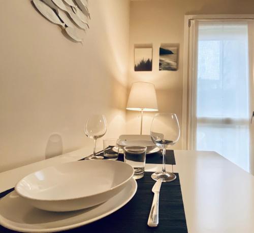 聖多納托米拉內塞的住宿－NEW - Nuovo appartamento in centro，一张桌子,上面放有两块白板和酒杯