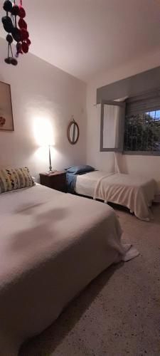 a bedroom with two beds and a lamp on a table at Bed & Breakfast Pleno Centro EN CASA PARTICULAR in San Luis