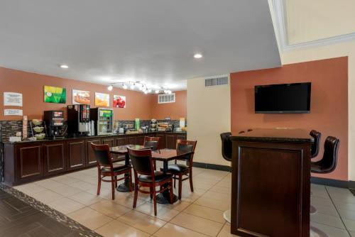 a restaurant with a bar with a table and chairs at Quality Inn Phenix City Columbus in Phenix City