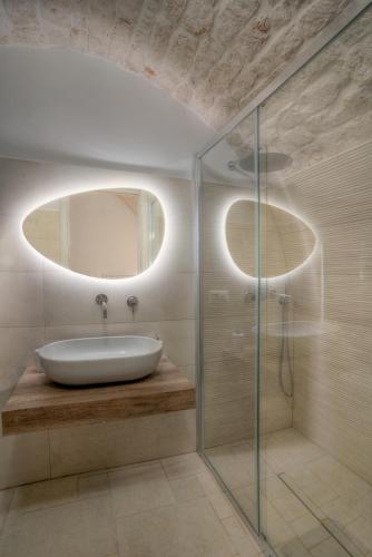 a bathroom with a sink and a glass shower at Home Pedra in Ceglie Messapica