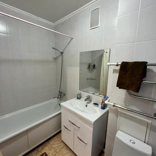 uma casa de banho com um lavatório, uma banheira e um WC. em Однокомнатная в новом районе Жана Кала em Qostanay