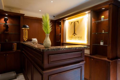 a lobby with a bar with a vase on it at Terraform Hotel in Lagos