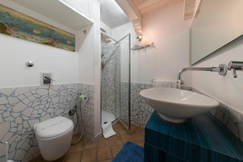 Un baño con lavabo, inodoro y ducha. en Cambusa del Capitano, en San Vito lo Capo