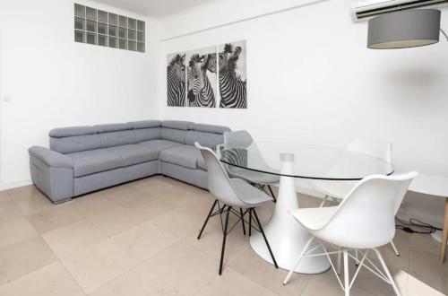 un salon avec un canapé, une table et des chaises dans l'établissement C082-Croisette - 2 Chambres - Vue Epoustouflante, à Cannes