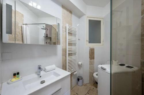 a white bathroom with a sink and a toilet at Croisette - 2 Chambres - Vue Epoustouflante in Cannes