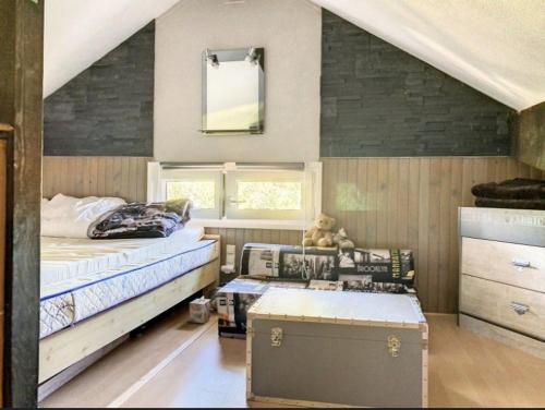 a bedroom with a bed and a table in it at Refuge de l'Ecureuil in Métabief