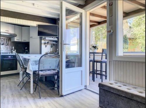 uma cozinha com uma mesa e uma porta de vidro deslizante em Refuge de l'Ecureuil em Métabief