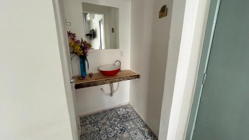 a hallway with a red bowl on a shelf and a mirror at Casa Tuxi in Rio de Janeiro