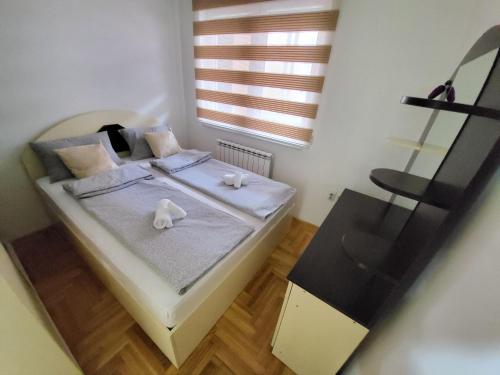 un dormitorio con una cama con dos animales de peluche en Apartman KostaS, en Lukavica