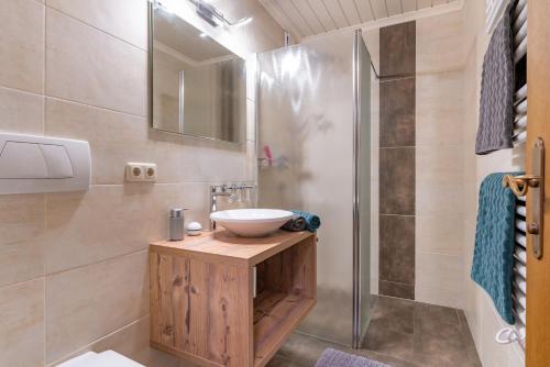 La salle de bains est pourvue d'un lavabo et d'une douche. dans l'établissement Landhaus Kendler, à Saalbach-Hinterglemm