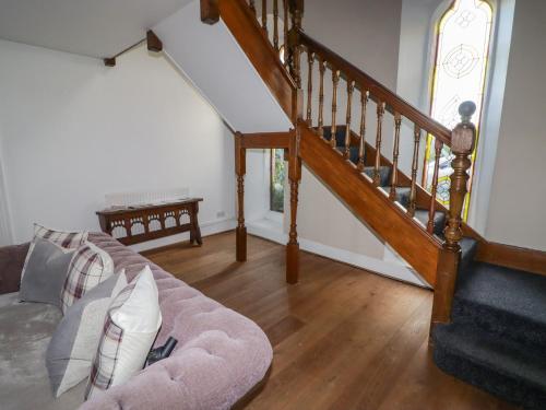 a living room with a couch and a staircase at The Chapel in Merthyr Tydfil