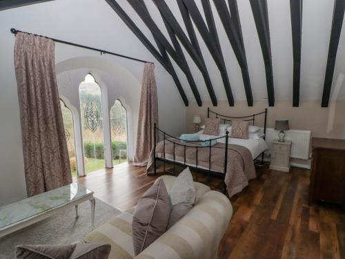 ein Wohnzimmer mit einem Bett und einem Sofa in der Unterkunft The Chapel in Merthyr Tydfil