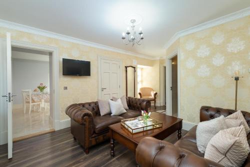 a living room with two couches and a table at The Old Schoolhouse of Warren Lodge Boutique Cottages in Dromod