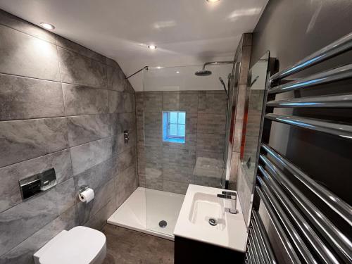 La salle de bains est pourvue d'un lavabo, de toilettes et d'une baignoire. dans l'établissement Cathedral View, à Tideswell